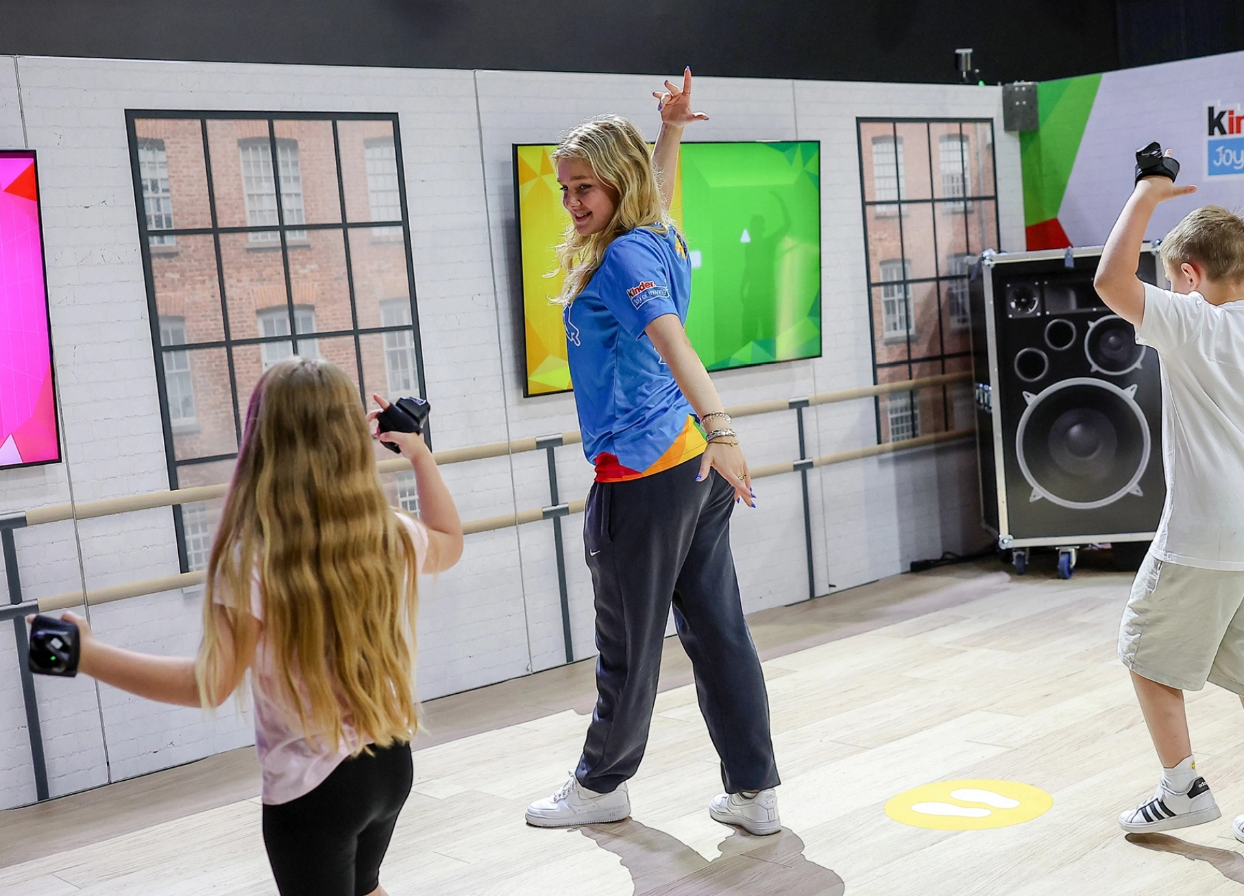 Kinder tanzen zusammen mit einem Influencer auf dem Joy of Moving Event.