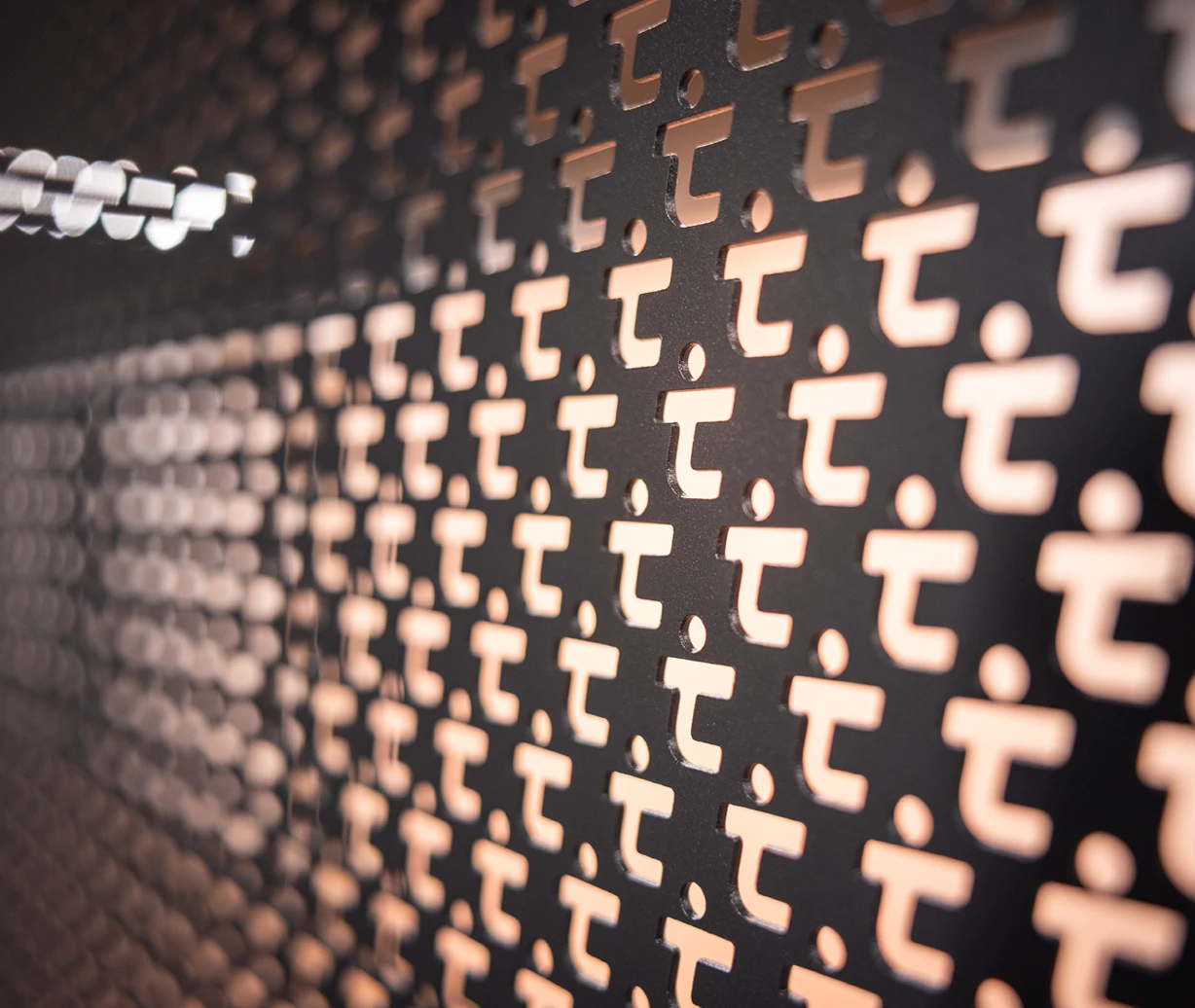 Office-Konzept: Nahaufnahme der verwendeten Materialien – schwarzes Lochrasterblech mit ausgestanztem Tipico Logo