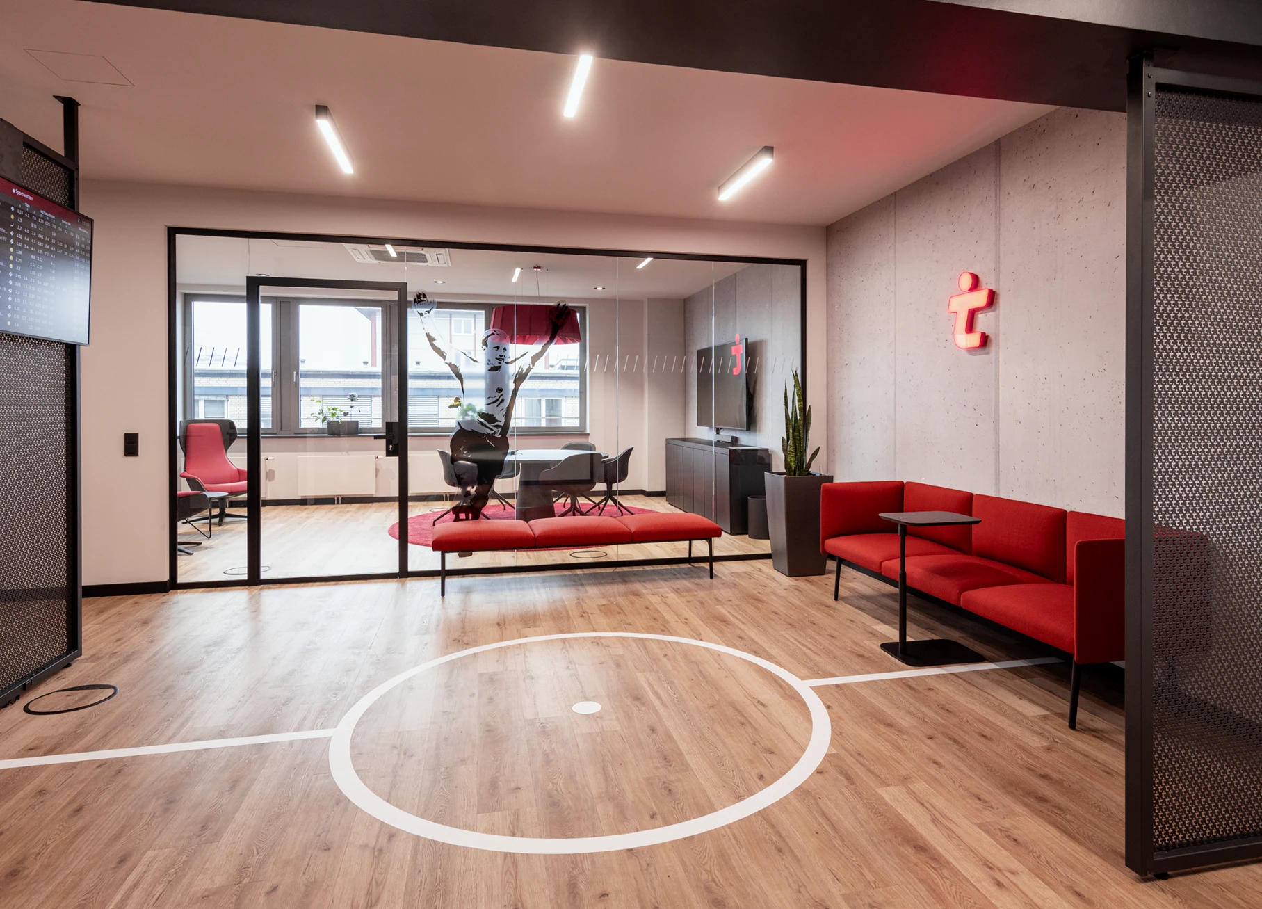 Office-Konzept: Blick in einen modernen Konferenzraum, mit Betonwand und Neon-Logo und Soft Work Sofa, Grafische Folierung auf dem Boden