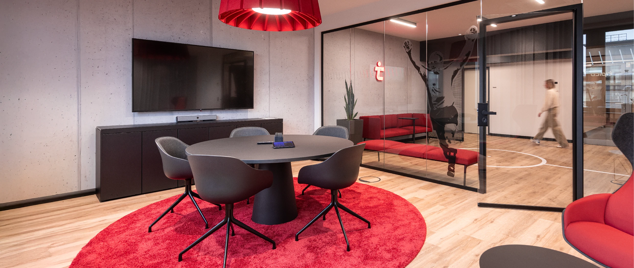 Office-Konzept: Blick in einen modernen Konferenzraum, mit Glastrennwand, Sofas, grafischer Scheibenfolierung