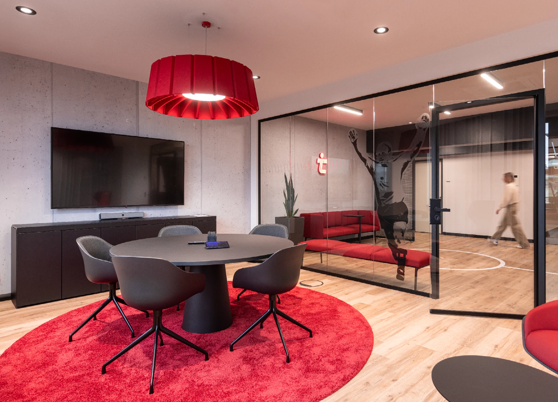 Office-Konzept: Blick in einen modernen Konferenzraum, mit Glastrennwand, Sofas, grafischer Scheibenfolierung