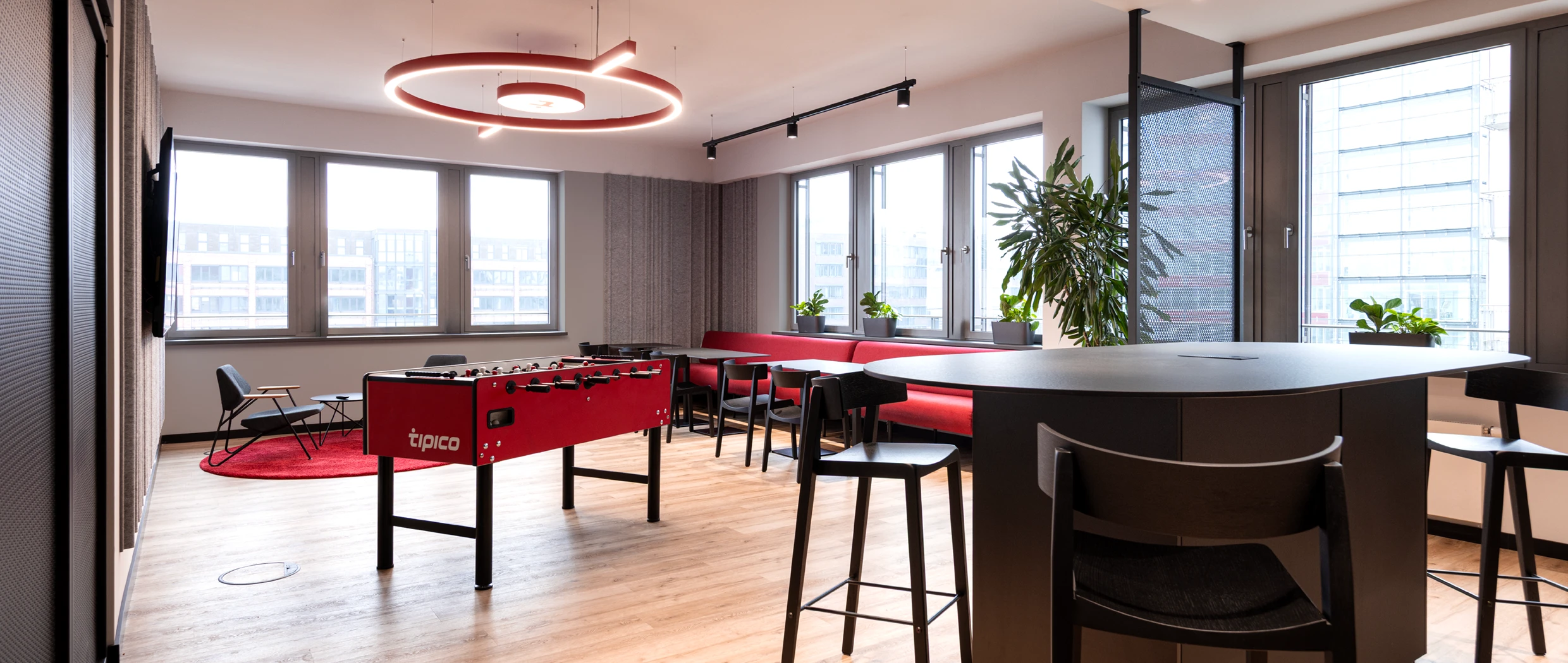 Office-Konzept: Zeigt die vergrößerte Küche mit Sozialbereich und Play Area. Marken-Elemente aus dem Tipico Shop Design sind in eine moderne Arbeitswelt übersetzt worden.